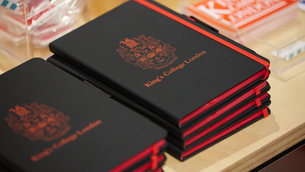 A pile of branded notebooks on a table